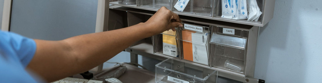 Clinician restocking labeled supply bins in a clinic storage room